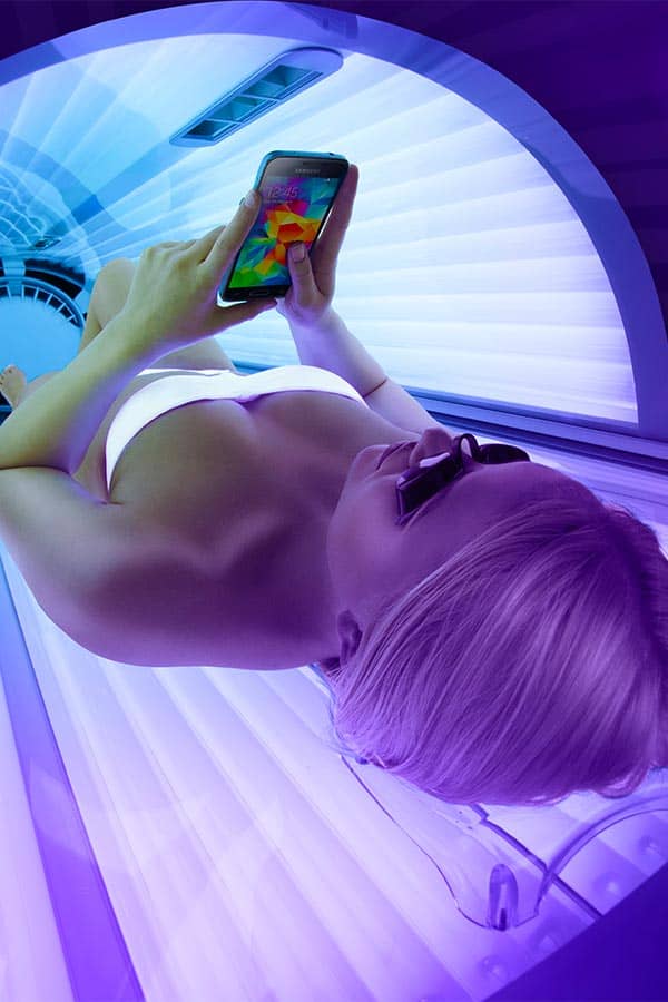 Ultrasun Q142 tanning bed with woman on phone